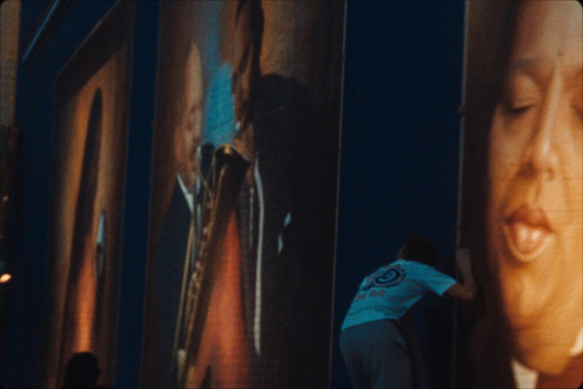 A large mural on a city wall honoring jazz musicians, painted in deep navy and gold tones, lit by late-afternoon sun.